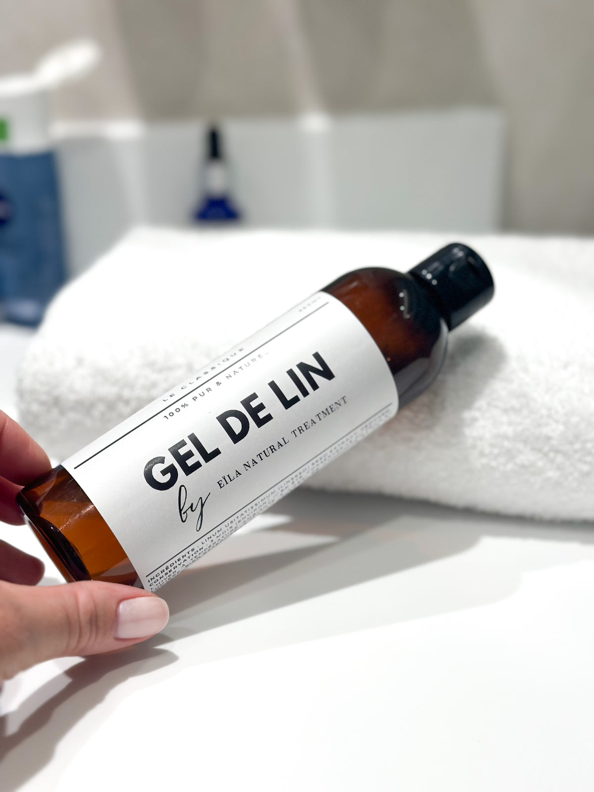 Flacon de Gel de Lin Pur Eïla tenu à la main, gel coiffant naturel pour cheveux bouclés